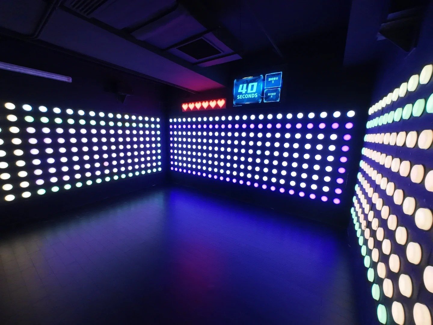 In the Spot & Push game room, there are many LED buttons with similar colors on the wall.