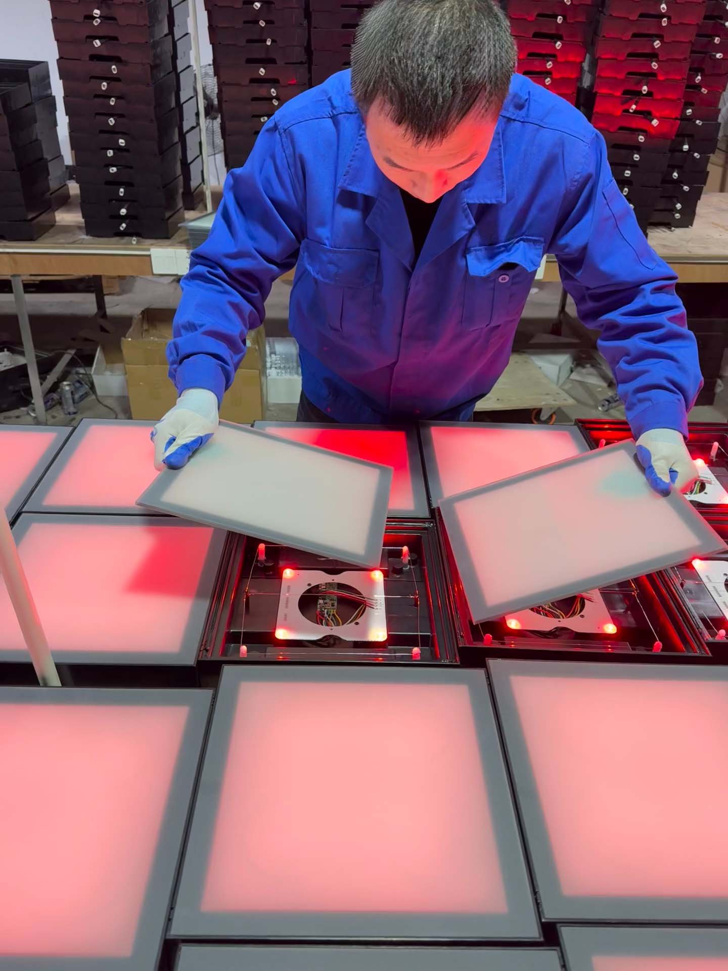 Workers assembling tempered glass screen for Mega Grid