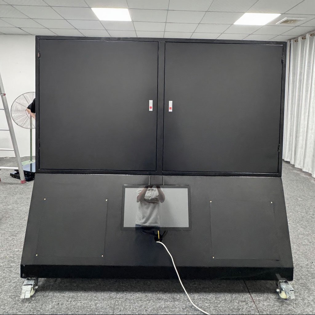 Large, black freestanding sensing sports wall unit on wheels with closed upper panels and a small lower touchscreen in an office.