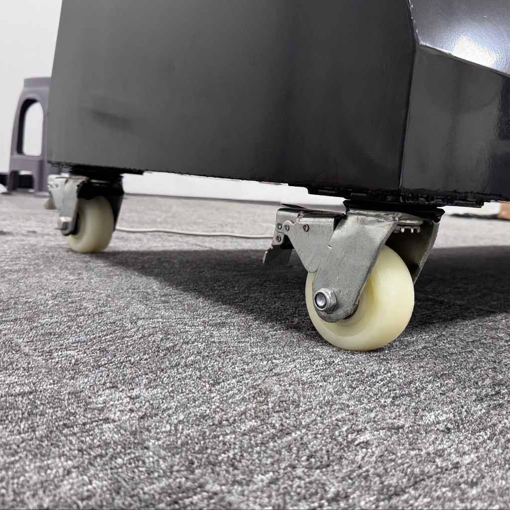 Close-up of white locking caster wheels at the base of a black sensing sports wall.