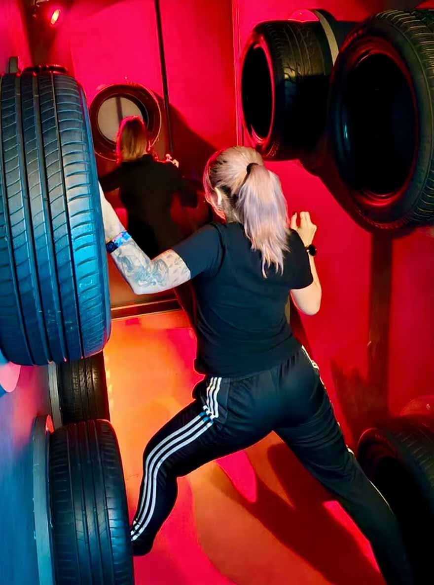 Zwei Mädchen spielen Suspended Tire Challenge und stehen auf Reifen.