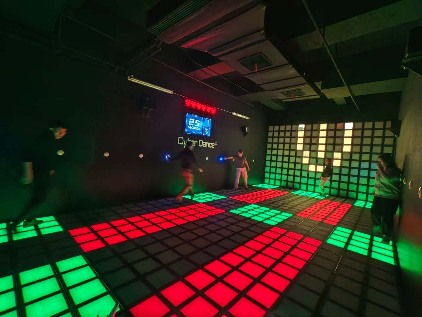 In the interactive game floor game room, players cooperate with each other, press the wall buttons, and avoid the red blocks on the ground