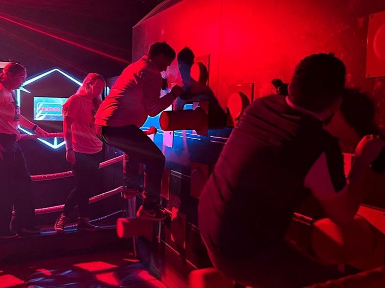 Multiple players are playing the game Knock Out, climbing on rocks and dodging punches.