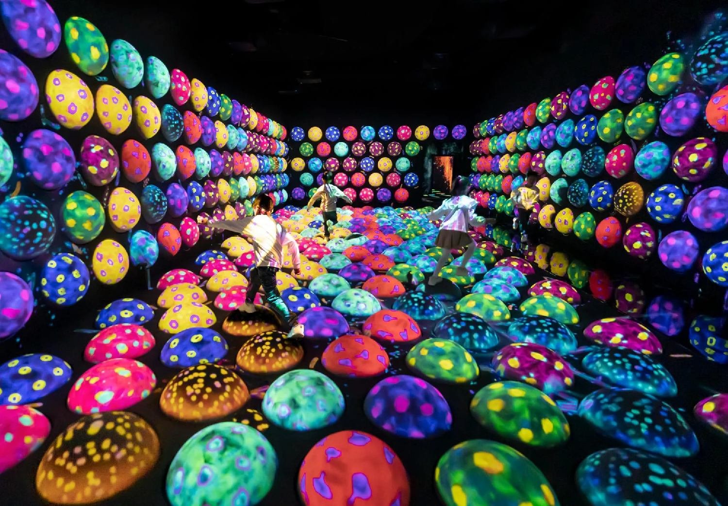Three children are playing a game in a room filled with spheres, called Rapidly Rotating Bouncing Spheres.