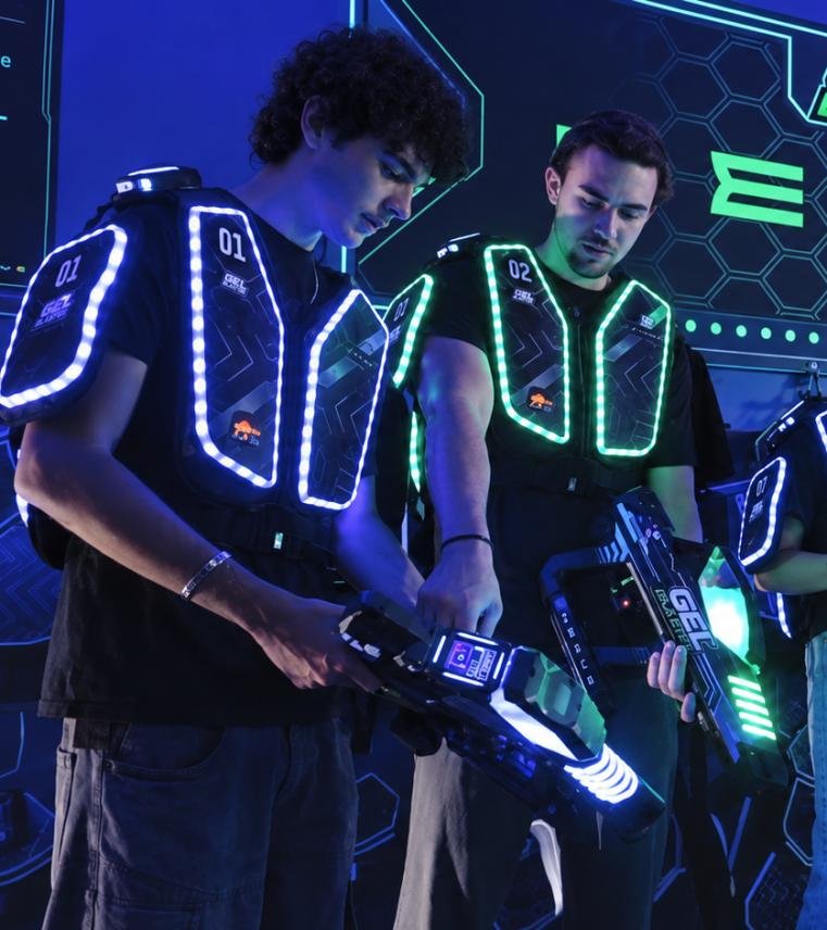 Players wearing LED sensor vests and holding gel blasters in a Gel Blaster Team Battle arena.