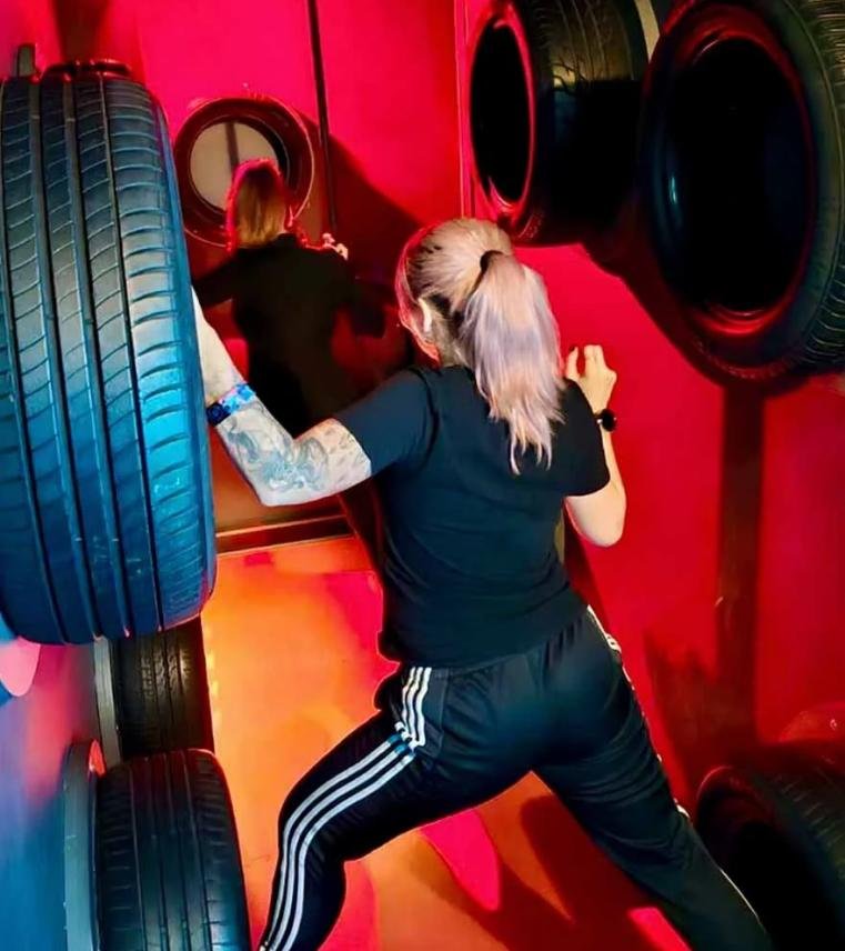 A player climbing wall-mounted tires to cross without touching the ground in a Restricted Zone challenge room.