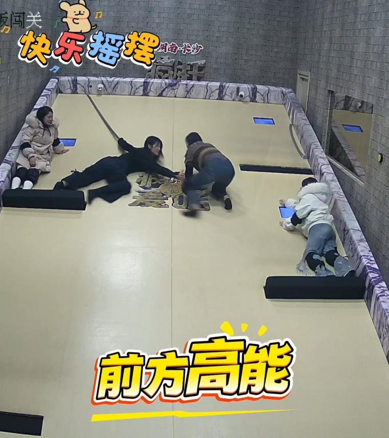 Players climbing up a continuously tilting smooth ramp to reach the top button in a Tilting Floor challenge room.