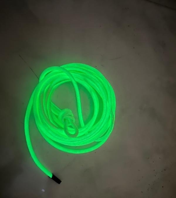 Coiled green glowing UV fluorescent rope used as a safety and visual component for the Rope Balance Challenge Swing Crossing.